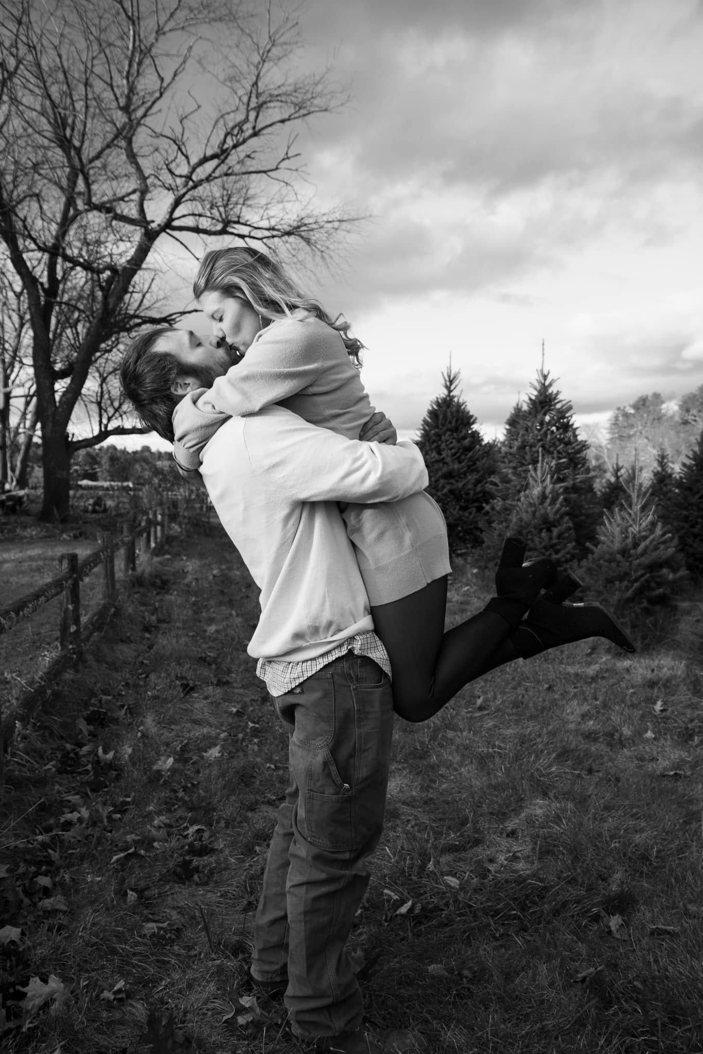 Couple embracing in the tree farm fields